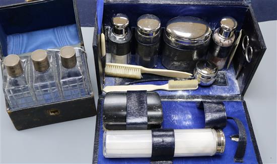A set of three silver-mounted cut glass toilet bottles, cased and another cased toilet set with plated fitments